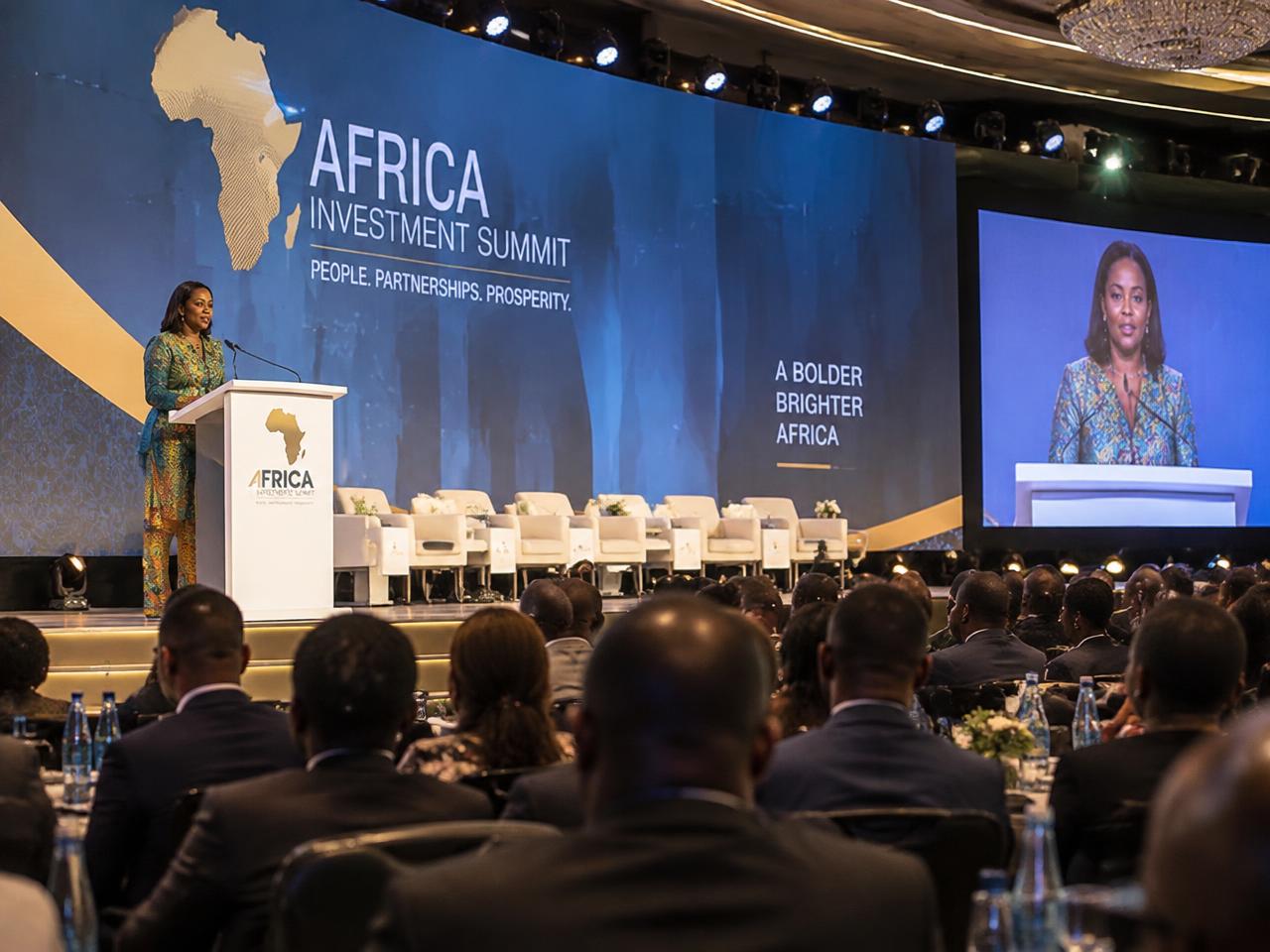 African woman speaker addressing a large international business summit audience